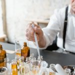 senior male preparing natural fragrance mixtures indoors using lab tools
